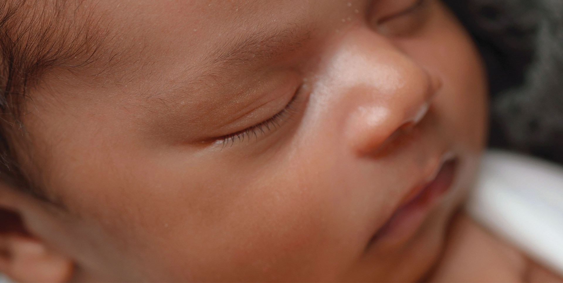 close-up portrait of a sleeping baby with serene facial features in a soft lighting, conveying a sense of comfortable sleep