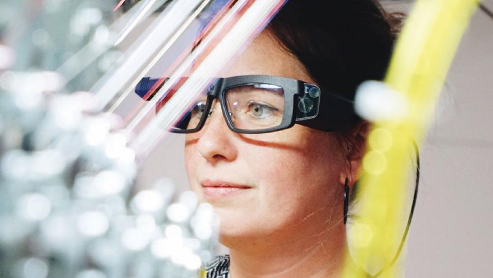 Employee with safety glasses examining textile machinery